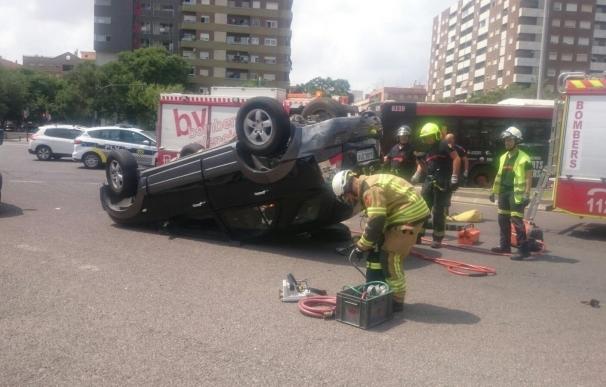 Rescatan a la conductora de un coche volcado en València tras chocar con un autobús de la EMT