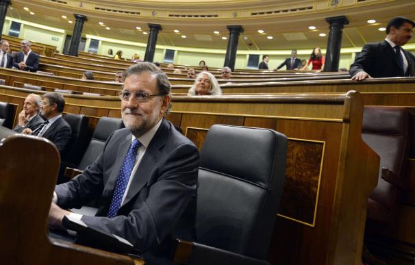Spanish Prime Minister Mariano Rajoy sits before t