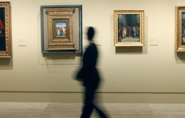 Una persona pasa ante varios de los cuadros de la exposición 'Obras maestras de Budapest. Del Renacimiento a las Vanguardias'. Foto: EFE/Javier Tormo