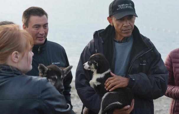 Barack Obama sostiene en brazos a un cachorro en Kotzebue, Alaska el 2 de septiembre
