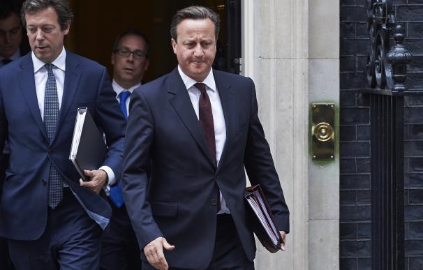 British Prime Minister David Cameron (C) exits 10