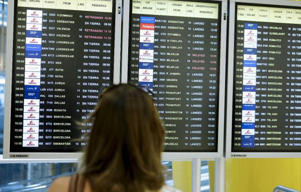 Una mujer observa los paneles de información de los vuelos en el aeropuerto de Barcelona