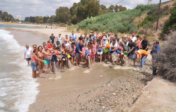 Más de un centenar de personas participan en una "regeneración simbólica" de la playa de Guadarranque