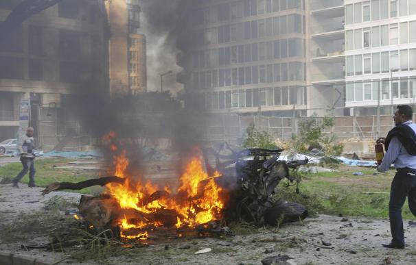 Las llamas calcinan un vehículo en el lugar donde se produjo una gran explosión que le ha costado la vida al exministro libanés de Economía Mohamed Chatah.