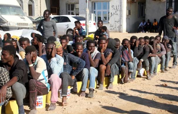 Migrantes ilegales se sientan en un puerto en Tagiura, al este de la capital libia, Trípoli, después de 137 inmigrantes de origen africano fueron rescatados por barcos de la guardia costera en la costa de Libia el 21 de julio de 2016.