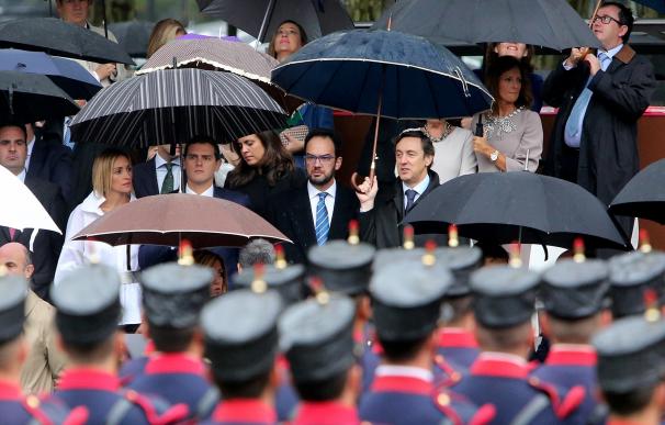 La lluvia convierte el desfile militar en una metáfora de la investidura: dirigentes de PP y PSOE bajo el mismo paraguas