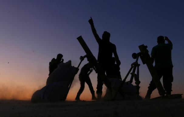 Fighters from the Free Syrian Army cheer and react as they fight against the Islamic State (IS). AFP
