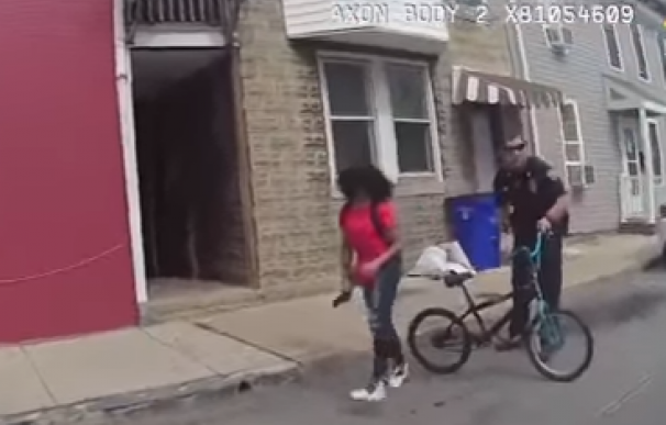 La policía empuja y rocía con pimienta a una joven negra que se cae de una bici