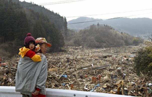 Dos habitantes de la zona afectada por un tsunami contemplan los destrozos ocasionados