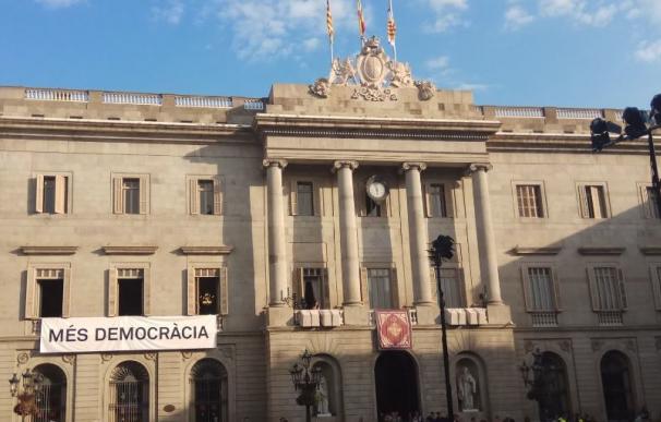 Colau cuelga una pancarta con el lema "Més Democràcia" por la Mercè