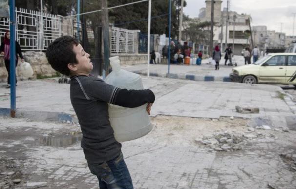 Un niño carga con un bidón de agua en la ciudad siria de Alepo / AFP