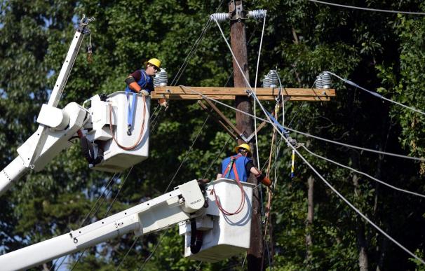 Dos operarios reparan un poste de luz en Virginia