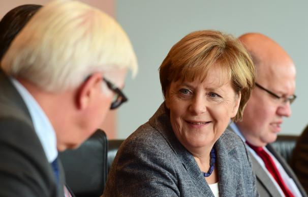German Chancellor Angela Merkel (C) speaks with Ge