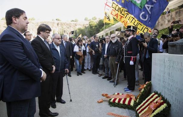 El presidente de la Generalitat, Carles Puigdemont (2i), junto al vicepresidente Oriol Junqueras (i), durante la tradicional ofrenda ante la tumba del presidente de la Generalitat republicana Lluís Companys