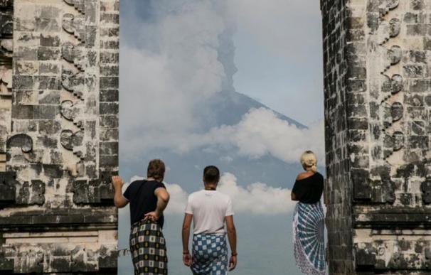 Fotografía de personas viendo el volcán Agung en erupción.