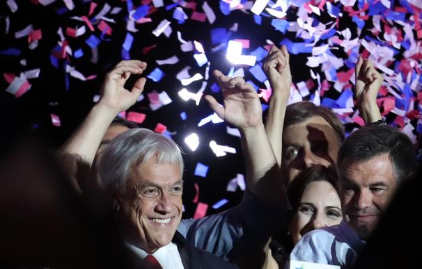 Sebastián Piñera (i), saluda a un grupo de simpatizantes tras ganar en los comicios
