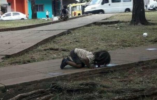 La fotografía de una niña argentina bebiendo agua de un charco.