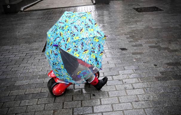 Un niño se refugia del temporal sin dejar la moto de los Reyes