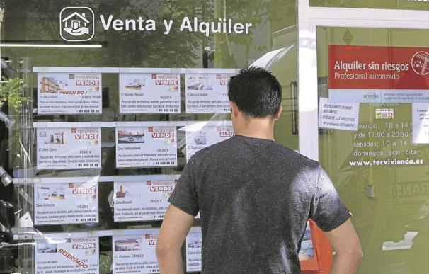 Un hombre mirando ofertas de pisos de alquiler en los expositores de una inmobiliaria de Madrid. - EFE