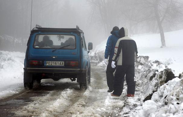 Un coche circula por una carretera secundaria en la montaña de O Cebreiro (Lugo) a 1300 metros de altitud. Las previsiones indican que las bajas temperaturas y la nieve se mantendrán toda la semana, incluso en latitudes de 400-600 metros. EFE/ Eliseo Trig
