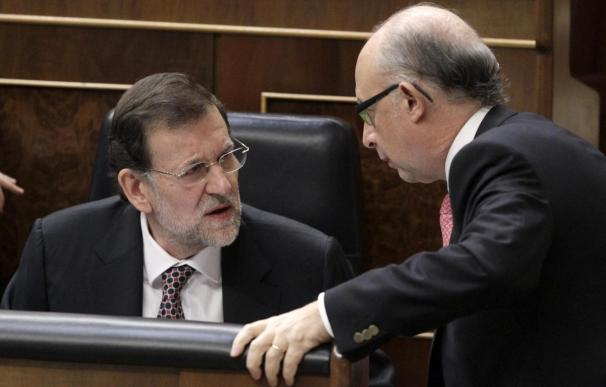 El presidente del Gobierno, Mariano Rajoy (i), conversa con el ministro de Hacienda, Cristóbal Montoro (d).