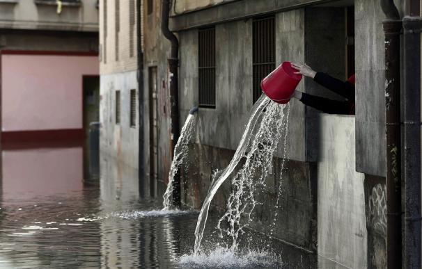 Una persona vierte el agua recogida que ha entrado en las cocinas de un restaurante de Tudela, tras la inundación que ha sufrido el casco viejo de la ciudad por la crecida del rio Ebro. ( EFE/Jesús Diges)