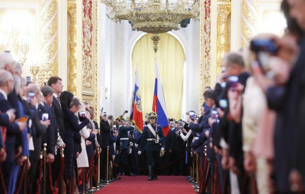 Miembros de la guardia de honor rusa desfilan, mientras portan la bandera nacional (centro-dcha) y el estandarte presidencial (centro-izda), durante la sesión de investidura de Vladimir Putin,
