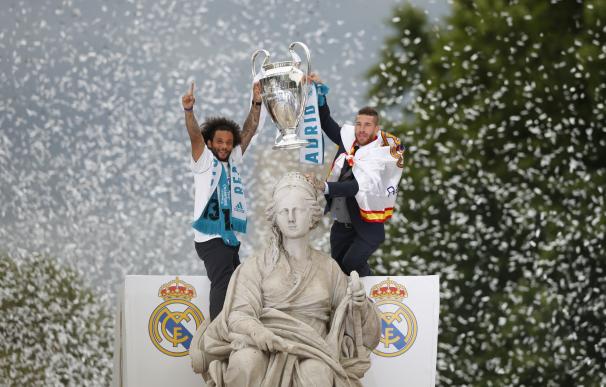 El defensa y capitán del Real Madrid, Sergio Ramos (d), alza la copa en la plaza de Cibeles, junto a su compañero el brasileño Marcelo, (EFE/ Javier Lizón)