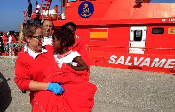 En Tarifa, una voluntaria de Cruz Roja traslada en sus brazos a una niña que viajaba en una de las pateras. EFE/A.Carrasco Ragel.