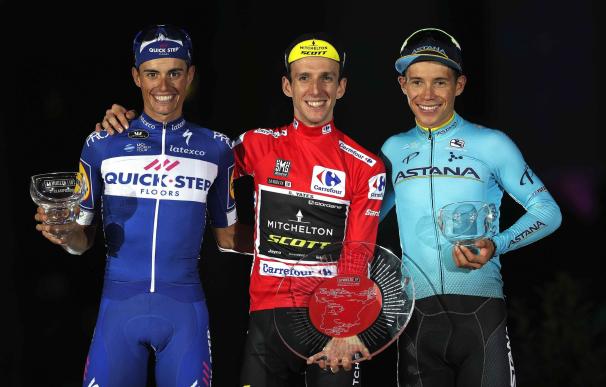 El ganador de La Vuelta 2018, el corredor británico del equipo Michelton - Scott, Simon Yates (c); el segundo clasificado, el español de Quick Step, Enric Mas (i), y el colombiano del Astana, Miguel Ángel López, tercero, en el podio al finalizar la Vuelta