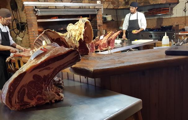 Los empleados de El Capricho, cortan los exquisitos filetes de carne de buey.