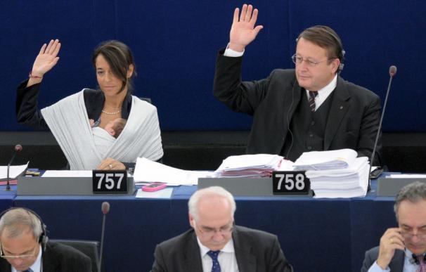 La eurodiputada Licia Ronzulli (i) sostiene a su bebé dormido en brazos mientras vota durante la sesión plenaria mensual del Parlamento Europeo en 2010. (EFE)