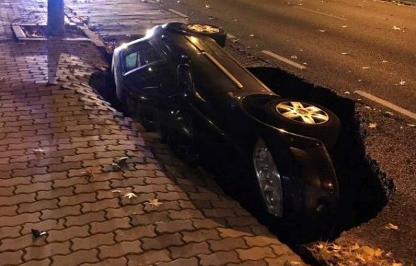 El hundimiento del asfalto en la avenida de Cardenal Cisneros, la calle con más tráfico de la ciudad de Zamora, ha provocado esta madrugada que un coche quedara hundido lateralmente en un socavón (EFE/Radar Zamora)