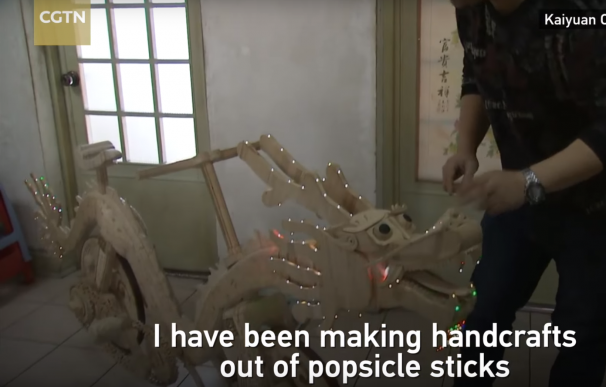 Un chino fabrica una bicicleta con forma de dragón hecha de palitos de helado.