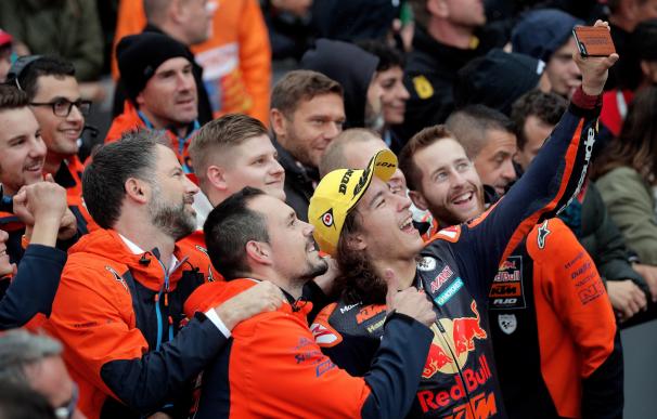 El piloto turco de Moto 3, del equipo Red Bull KTM, Can Oncu, es felicitado por sus compañeros tras ganar la prueba. EFE/ Kai Forsterling