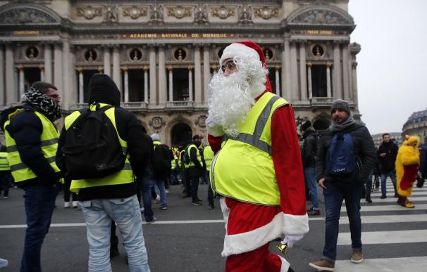 Un manifestante "chaleco amarillo" que viste un traje de Papá Noel asiste a una manifestación frente a la Ópera en París, Francia, el 15 de diciembre de 2018. (EFE/EPA/IAN LANGSDON)