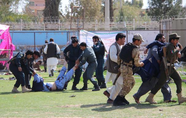 Varias personas ayudan a los heridos tras la doble explosión en la ceremonia del día de los granjeros, en Helmand (EFE / EPA / WATAN YAR).