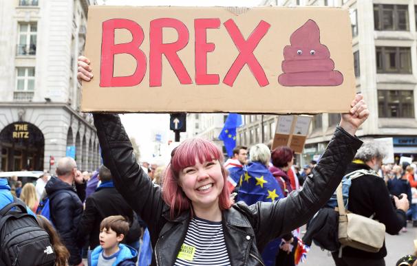 Una mujer sostiene una pancarta mientras la gente asiste a la marcha para exigir otro referéndum sobre el acuerdo final del Brexit. (EFE / EPA / FACUNDO ARRIZABALAGA)