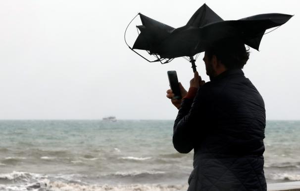 - Una persona hace una fotografía en la Playa de la Malvarrosa de Valéncia bajo la lluvia y el fuerte viento (EFE/Juan Carlos Cárdenas)