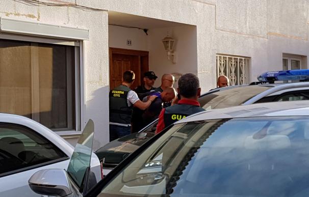 El ciudadano alemán que presuntamente asesinó a su mujer y a su hijo de 10 años, en la turística localidad española de Adeje, en la isla de Tenerife (Canarias), sale del registro de su vivienda escoltado por guardias civiles. / EFE