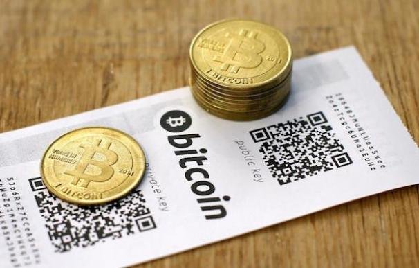Monedas bitcoin, las criptomonedas más famosa, sobre una mesa / EFE