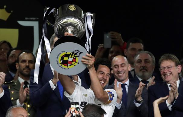 El capitán del Valencia CF, Daniel Parejo, levanta el trofeo tras vencer por 2-1 al FC Barcelona en la final de la Copa del Rey que ambos equipos han disputado esta noche en Estadio Benito Villamarín de Sevilla. EFE/Julio Muñoz