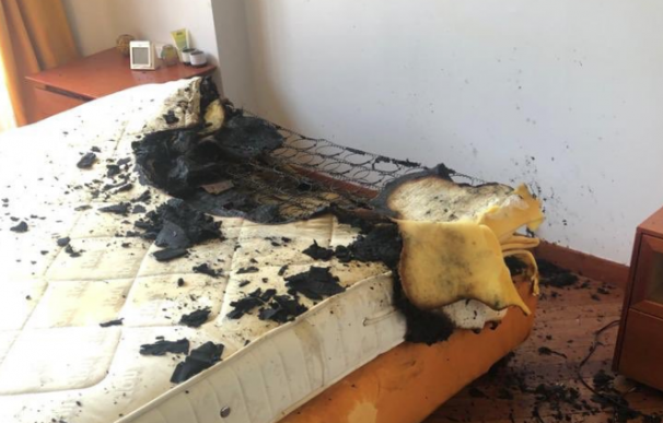 Fotografía del colchón calcinado por arder un cargador de móvil.