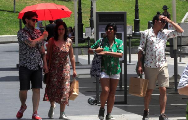 Varias personas intentan protegerse del calor en las inmediaciones del Museo del Prado. /EFE