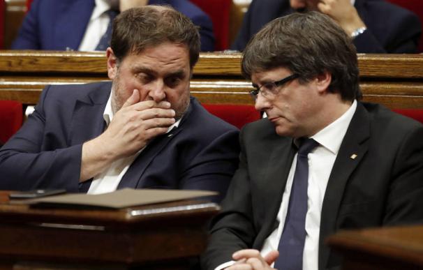 El expresidente de la Generalitat Carles Puigdemont (d) y el exvicepresidente Oriol Junqueras (i) en el Parlament. (EFE)