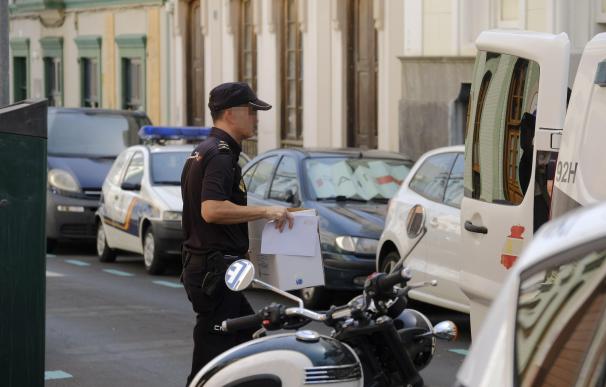 Un policía saca una caja del edificio del centro de Las Palmas de Gran Canaria donde este lunes un hombre ha matado a su expareja