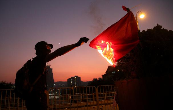 Un ciudadano quema una bandera de China. / EFE