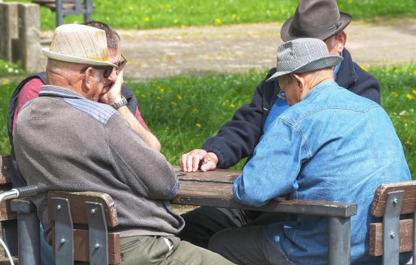 Fotografía de varios jubilados jugando al dominó.