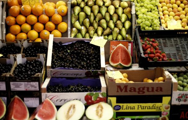 Naranjas, peras, limones, uvas, sandías, melones, fresas y cerezas en un mercado.