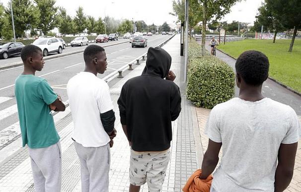 Un grupo de migrantes espera en la parte española del Puente de Santiago parta cruzar a Francia.